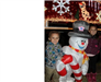 kid standing next to inflatable frosty the snowman