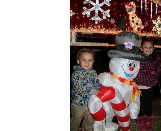 kid standing next to inflatable frosty the snowman