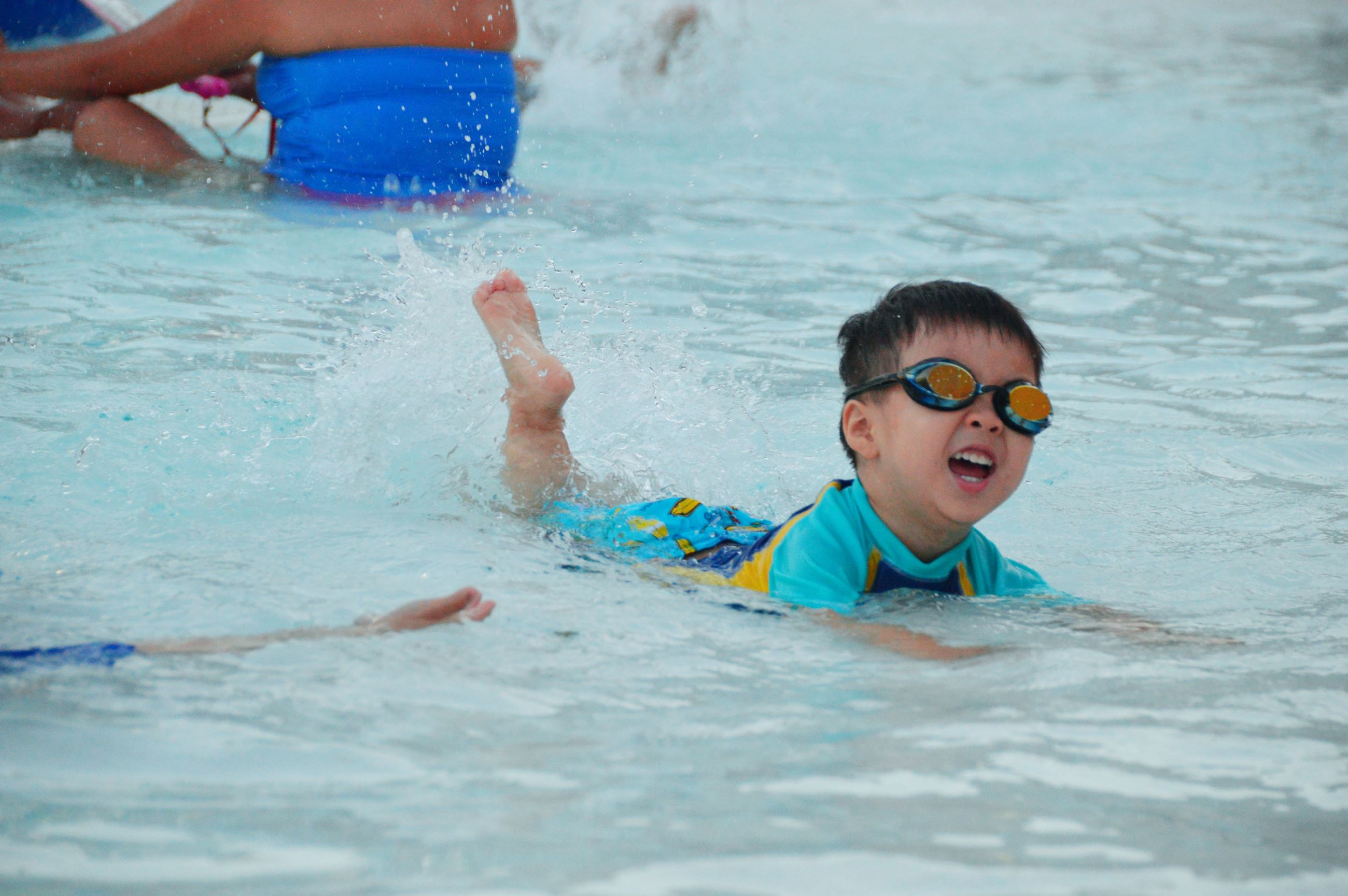 Little boy swimming in the outdoor pool