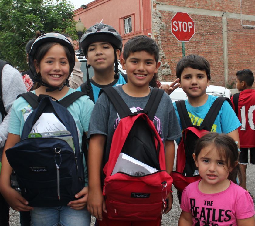 Students display happiness after receiving school supplies.