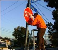 man working on stop sign